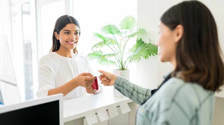 woman paying at salon