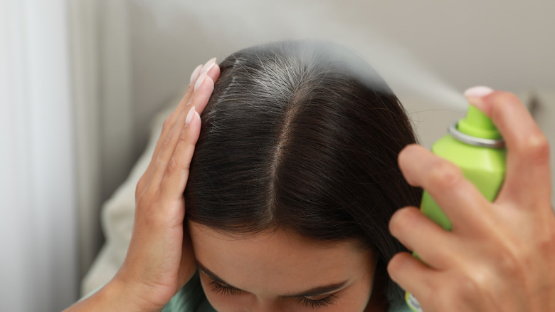 woman spraying dry shampoo