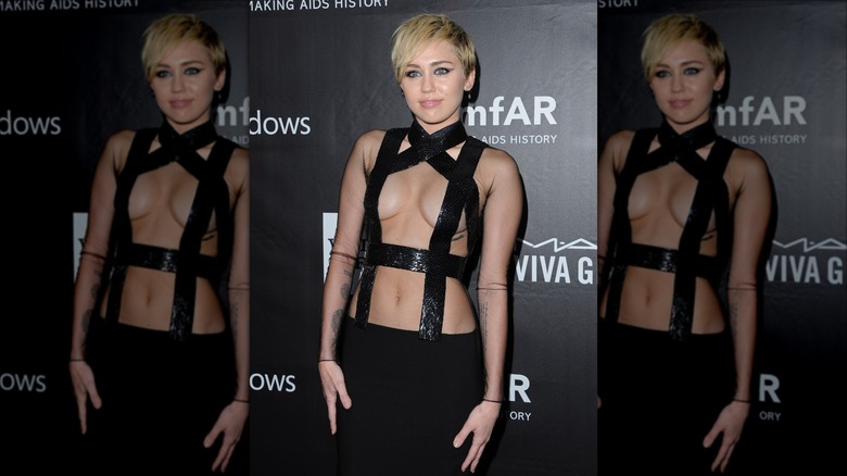 miley cyrus wearing black strappy risque dress