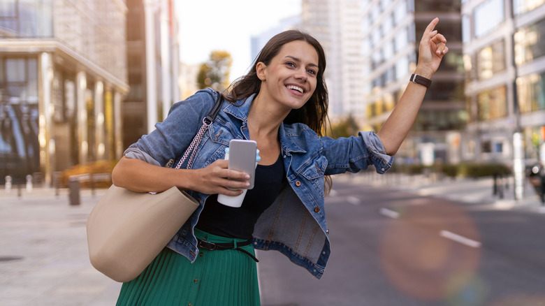 Woman hailing cab in city 