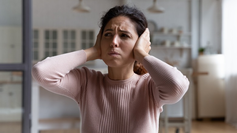 Woman plugging her ears 