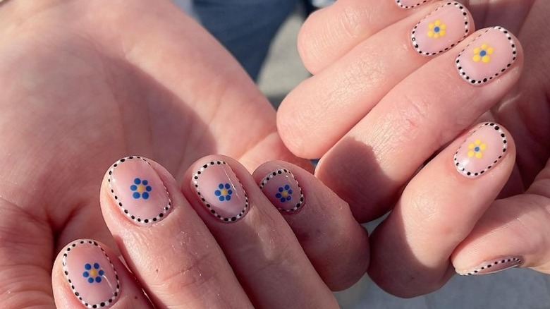 person with mismatched floral nails