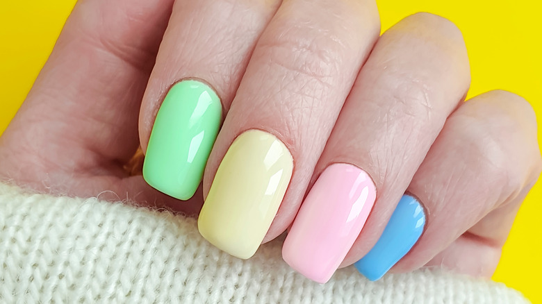 person with pastel colored nails