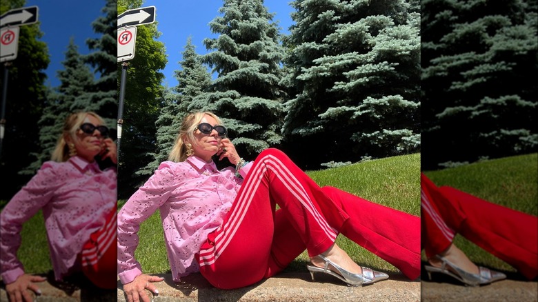 Girl wearing a button-down with track pants and heels.