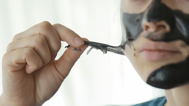 Woman peeling off face mask