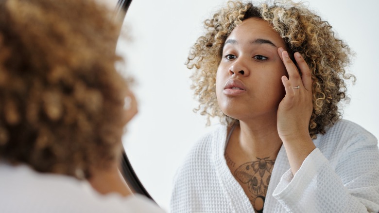 Woman in a bathrobe looking in the mirror