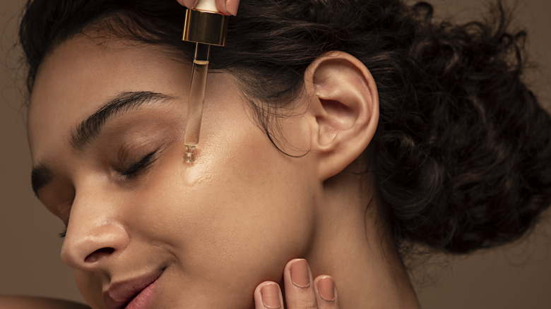 woman applying serum on face