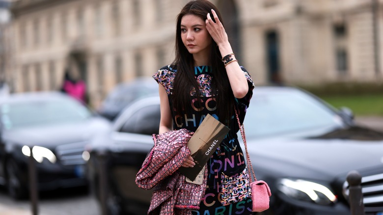 Woman with Chanel logo dress, purse, bracelet