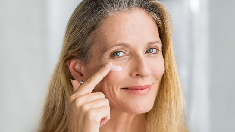 woman putting skincare on face