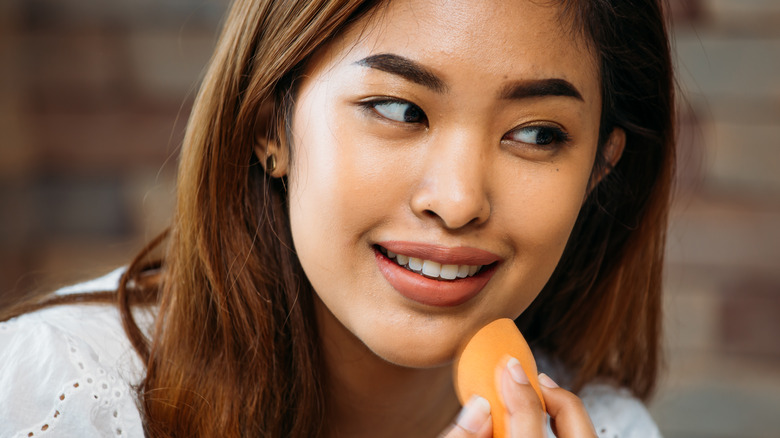 Applying makeup with sponge