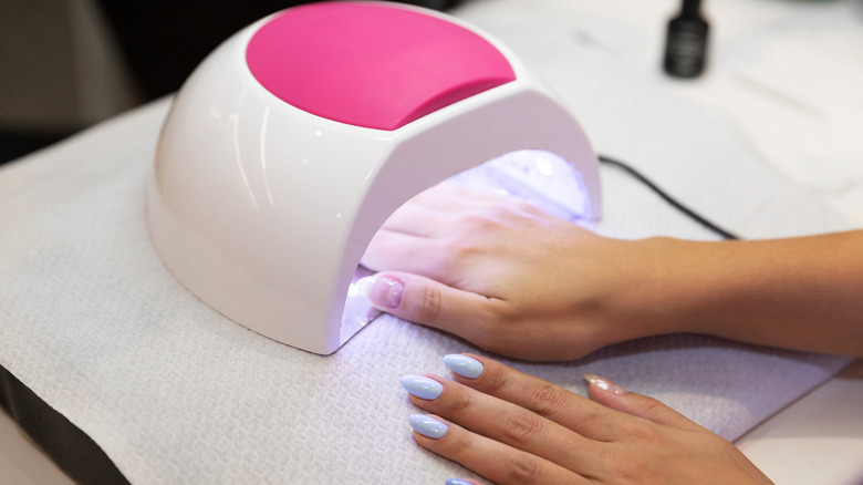 Hand in UV lamp to cure manicure