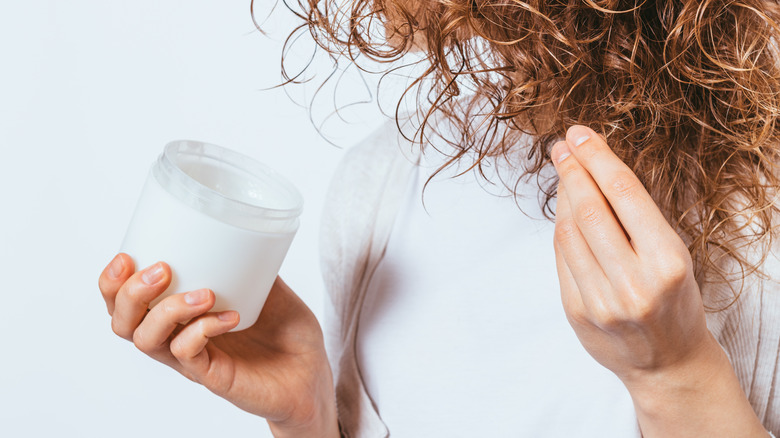 Person adding cream to hair