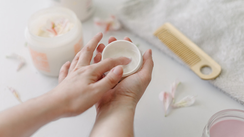 Person using jar of haircare