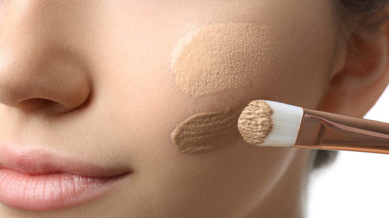 Woman applying darker concealer 