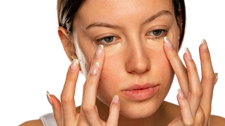 Woman applying concealer with her fingers