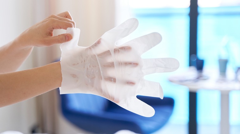 putting on moisturizing gloves