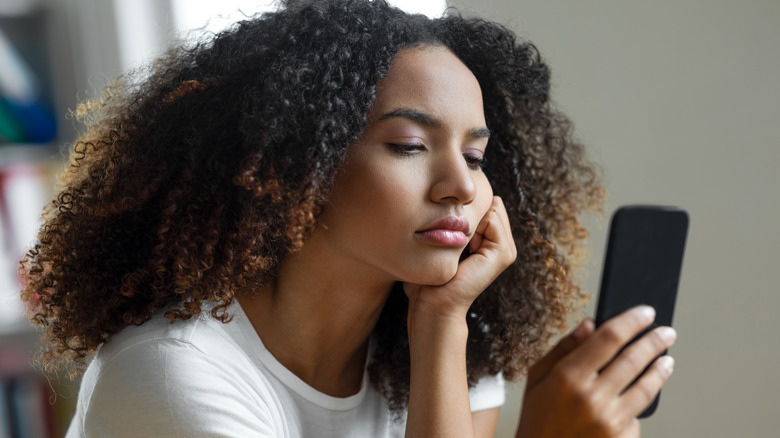 upset woman looking at phone