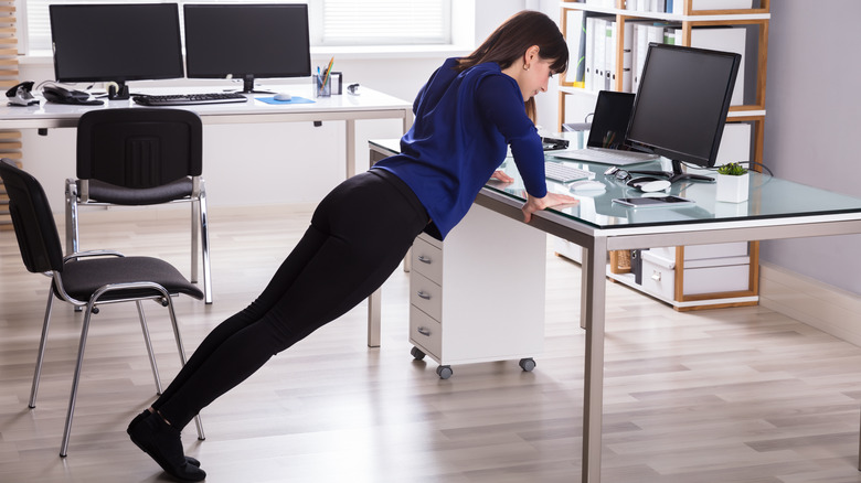 Woman doing pushups against desk