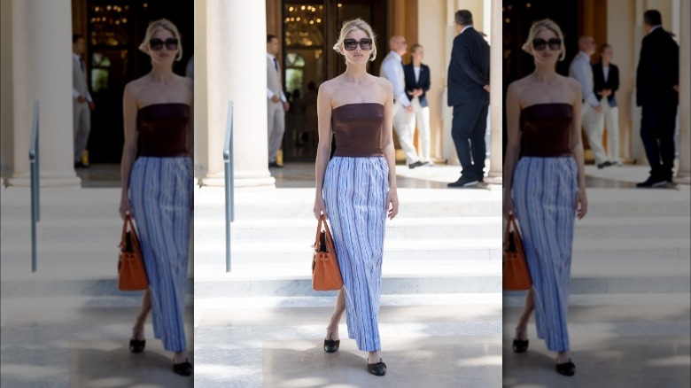 woman in striped skirt with black flat mules