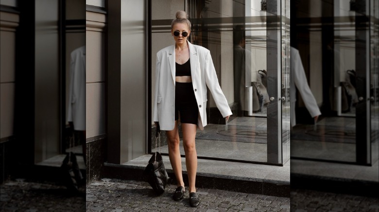 woman in white blazer with black loafers