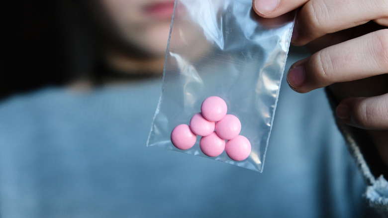 Woman holding bag of pills