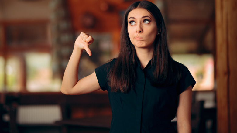 Woman making thumbs down gesture