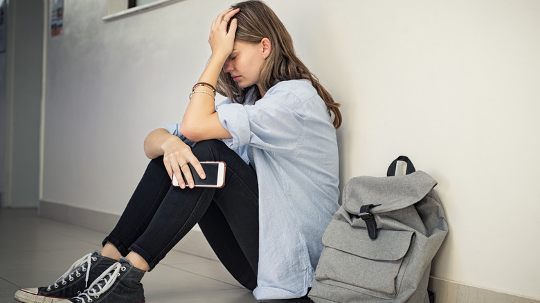 Teenager sitting on floor