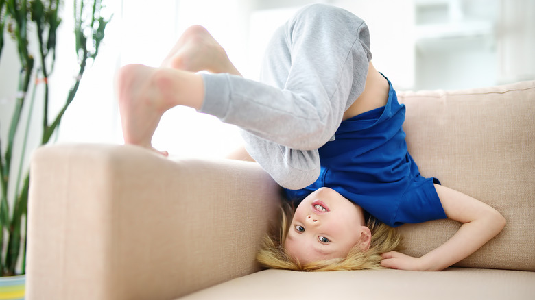 boy does headstand on sofa