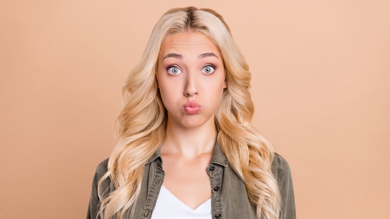 Woman with blond hair making face