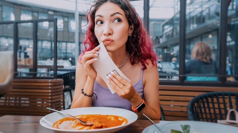 woman wiping mouth after eating