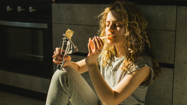 woman eating on kitchen floor