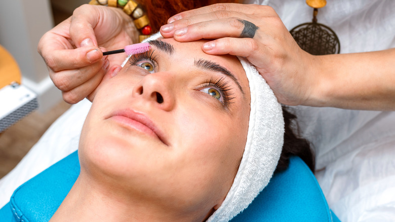 Woman on table getting lashes done