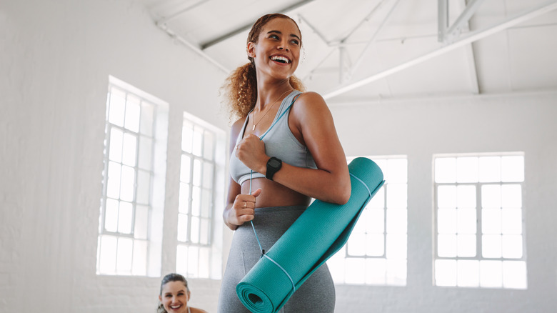 woman holding yoga mat