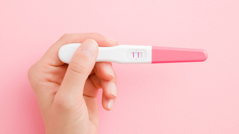 Person holding positive pregnancy test