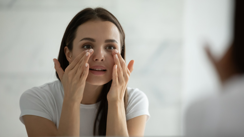 A woman putting skincare on