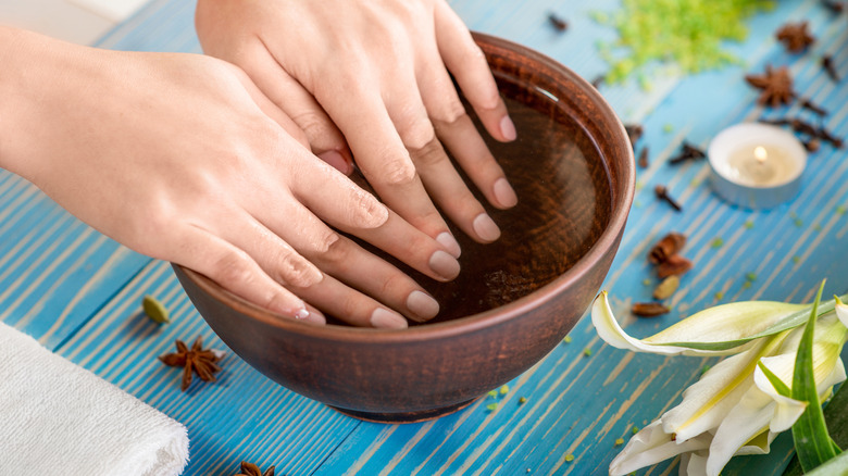 Person soaking nails in bowl