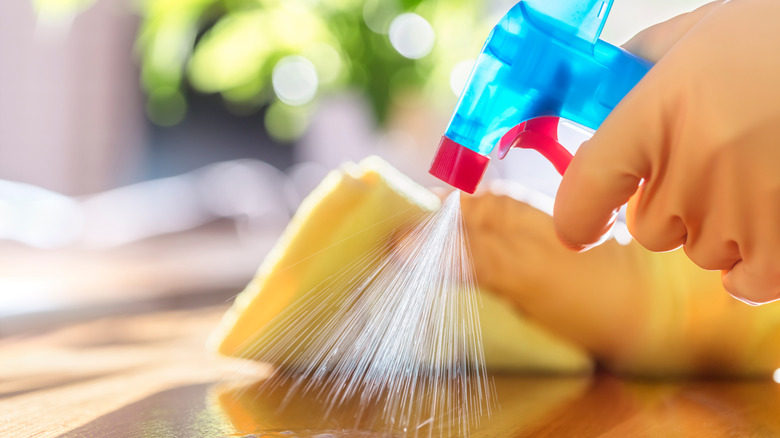 Person cleaning while wearing gloves