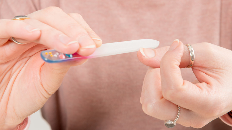 person using a cyrstal nail file