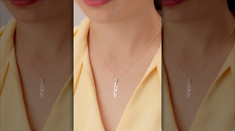 woman wearing vertical nameplate necklace