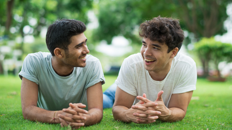 Couple talking, laughing on grass