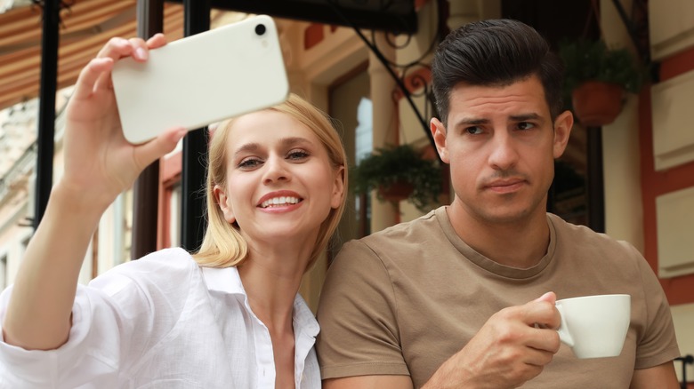 Man unhappy in selfie with partner