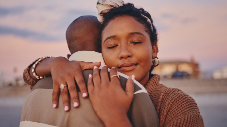 Black couple embracing at sunset