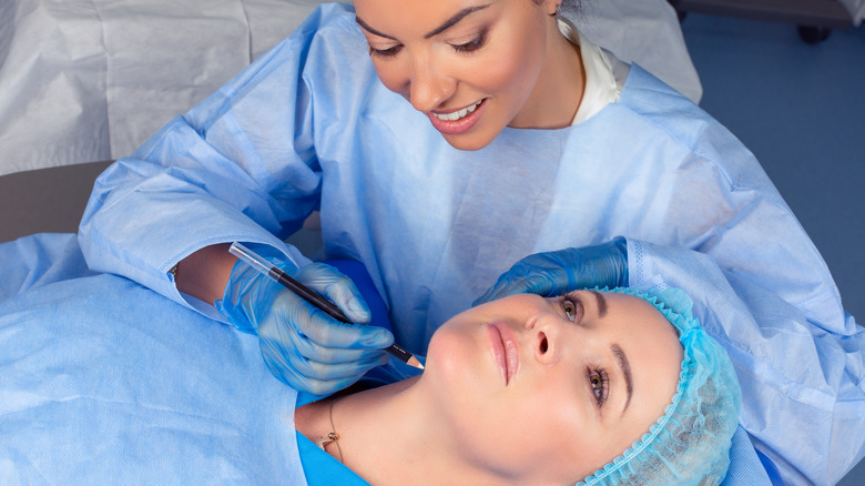 Surgeon draws lines on patient's neck