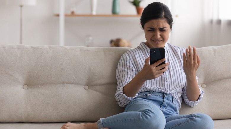 Confused woman looking at phone