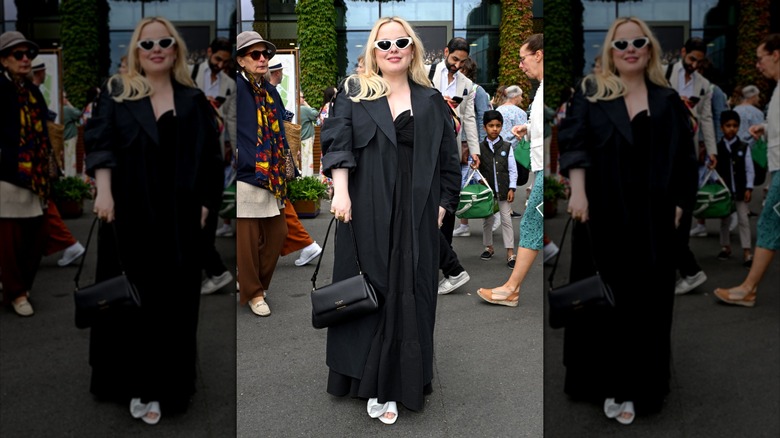 Nicola Coughlan wears a black maxi dress and trench coat at Wimbledon 2024.