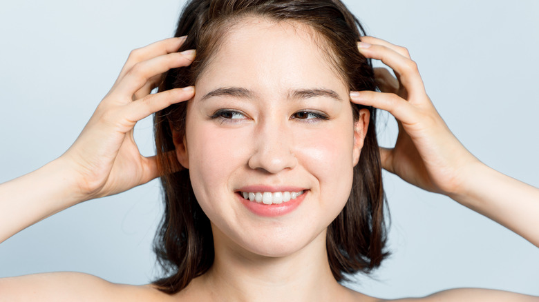 woman massaging her scalp 