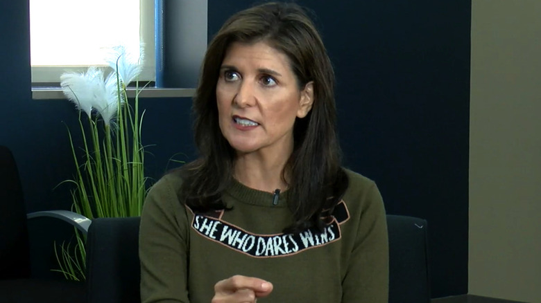 Nikki Haley in an interview wearing a sweater reading "She who dares wins."