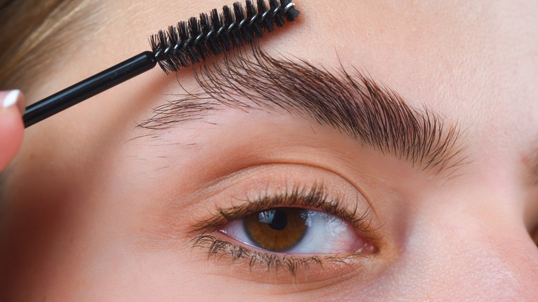 woman brushing up her eyebrows