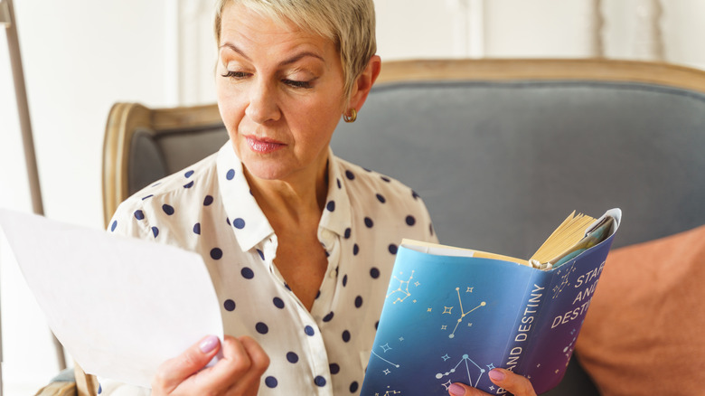 Woman holds astrology book