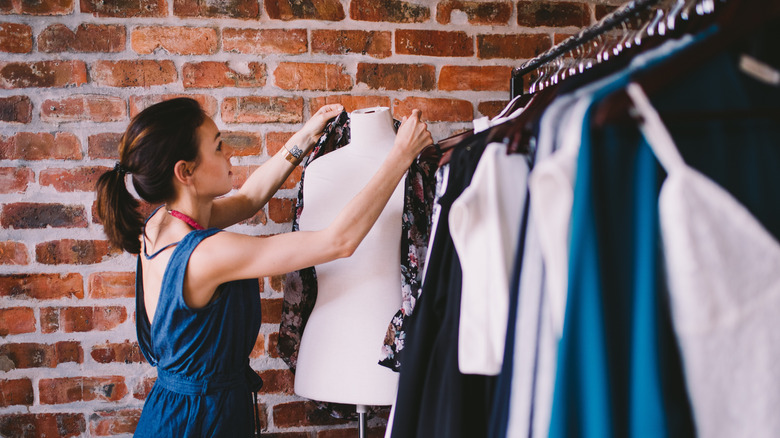 stylist putting a shirt on mannequin 